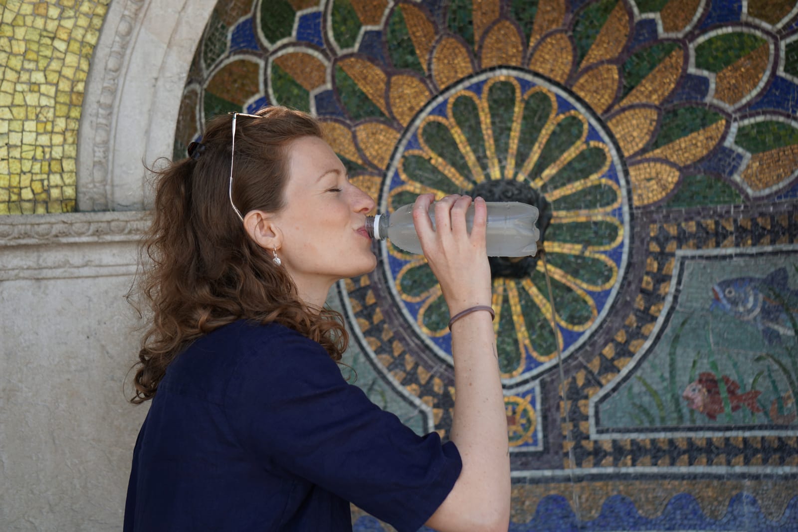 Woman drinking at mosaic fountain